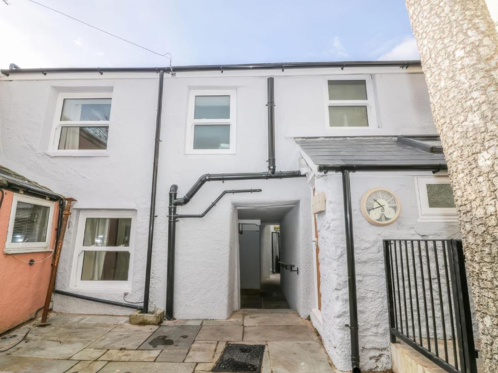 een wit huis met een garage en een klok bij Hocking Cottage in Torquay