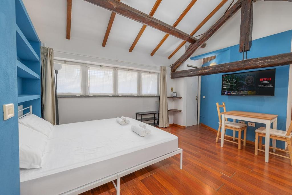 a bedroom with a white bed and a table at Easy Parking - 1 min from Bus to San Siro Stadium - Air Conditioning in Milan