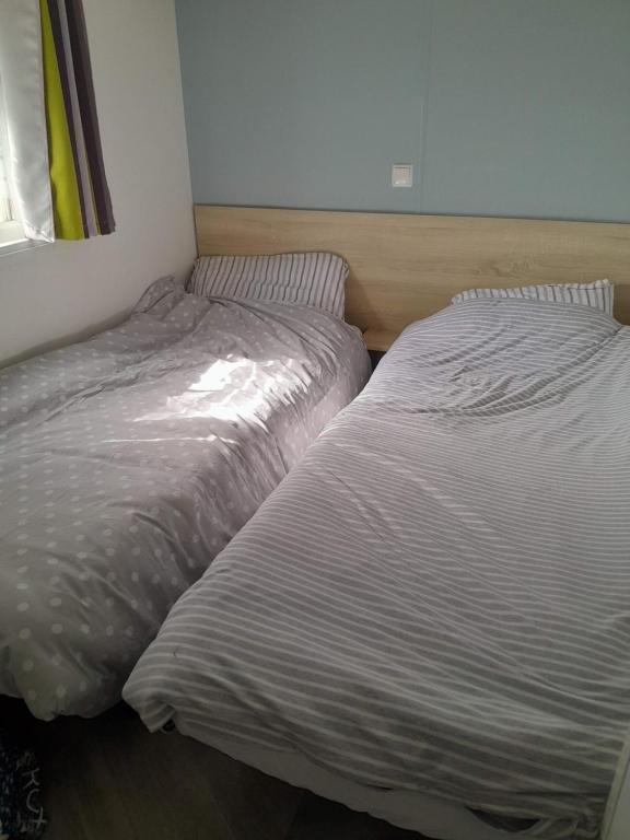 two beds sitting next to each other in a bedroom at WOW Holidays - 8 Person, 5 Star Mobile-Home with Terrace in Gastes
