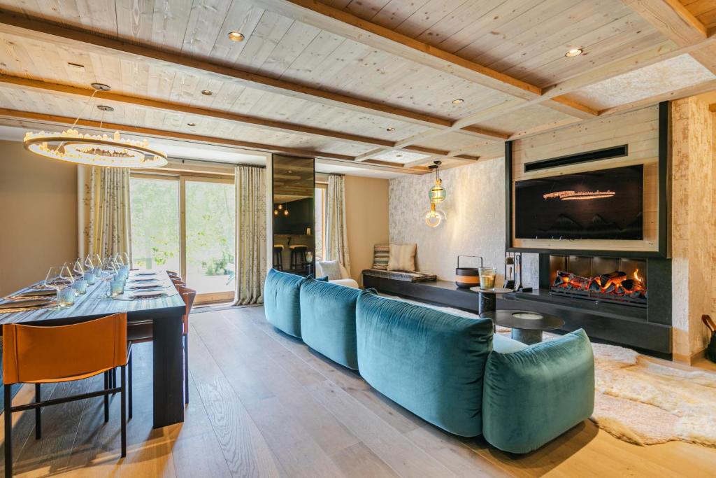 Rochebrune - Appartement de luxe في ميجيف: غرفة طعام مع طاولة وكراسي زرقاء ومدفأة