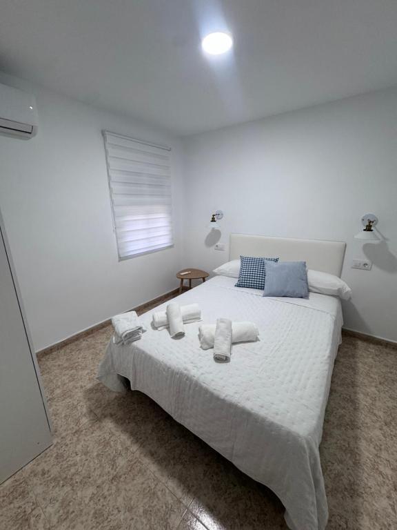 a bedroom with a white bed with towels on it at Alma azul in Puerto de Mazarrón