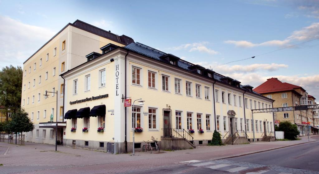 a large white building on the corner of a street at Clarion Collection Hotel Bergmästaren in Falun