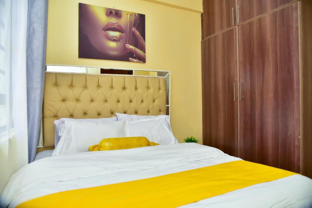 a bed with a yellow pillow on top of it at GJ'S 1 BEDROOMS KIAMBU Town in Nairobi