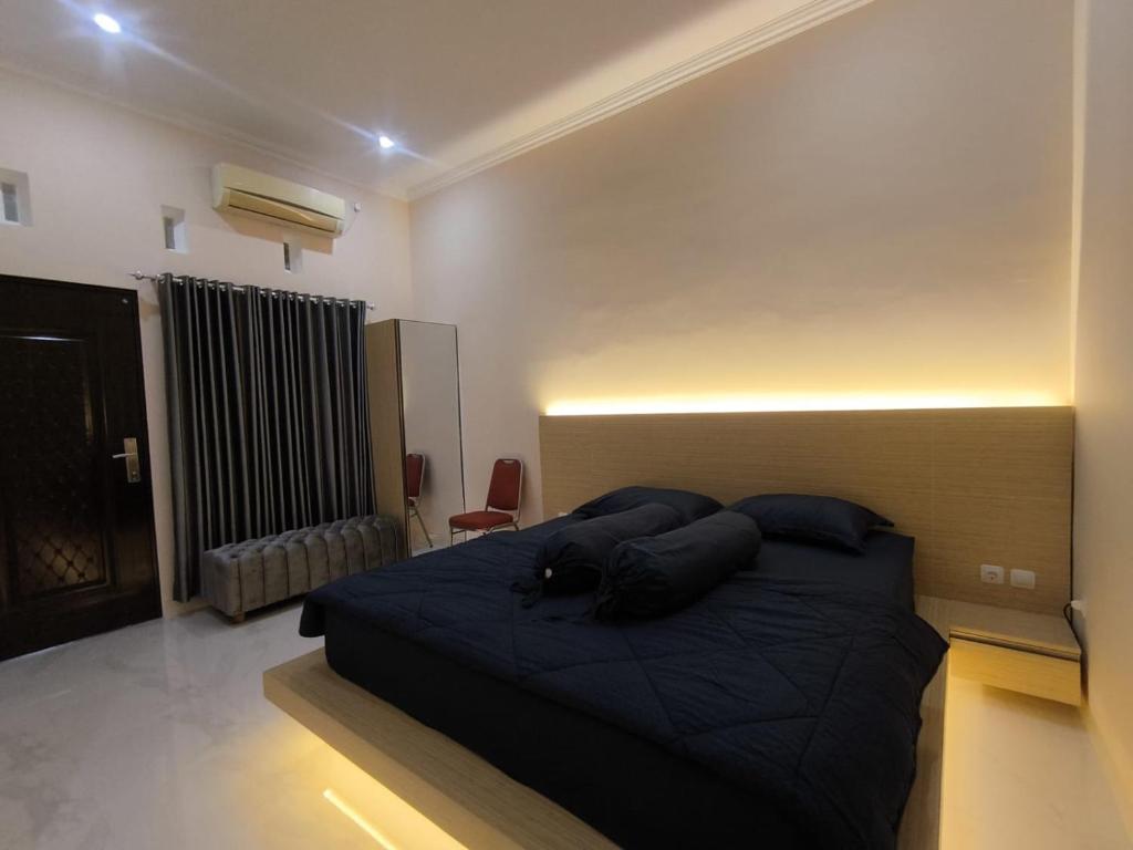 ein Schlafzimmer mit einem großen schwarzen Bett in einem Zimmer in der Unterkunft House of Toti in Yogyakarta
