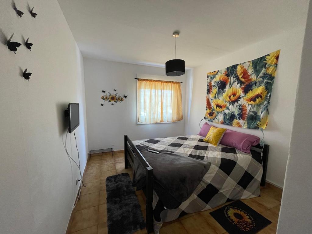 ein Schlafzimmer mit einem Bett und einem Gemälde an der Wand in der Unterkunft Traditional Peniche House in Peniche