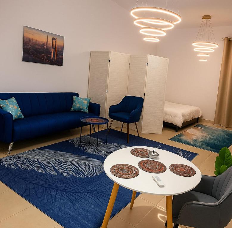 a living room with a blue couch and a table at Boutique Studio , Guest Suit , AJMAN in Ajman 