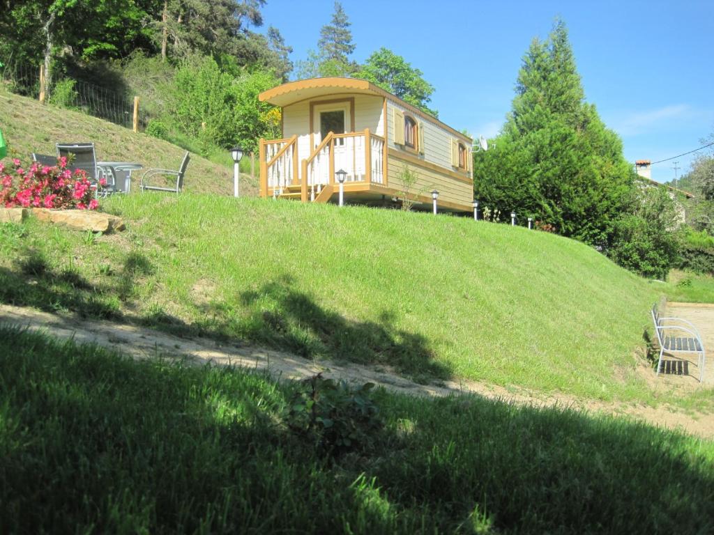 une maison au sommet d'une colline herbeuse dans l'établissement La Roulotte des Bords de l'Ance, à Tiranges