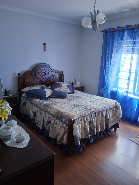 a bedroom with a bed in a room with blue curtains at Apartamento Braga in Braga