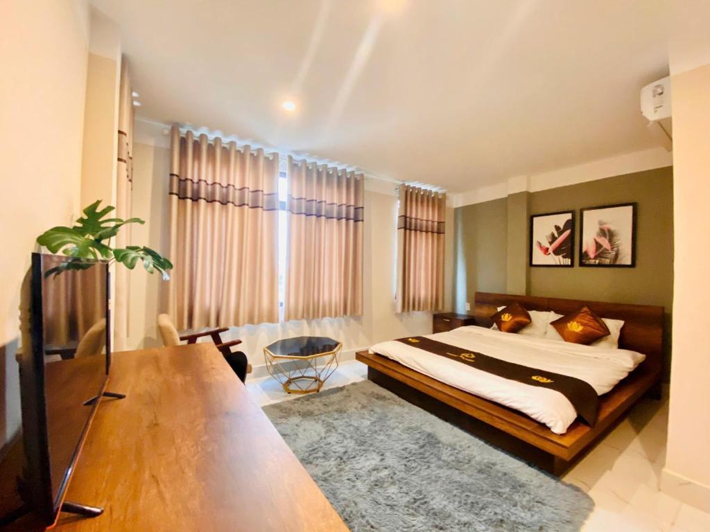 Tân UyênにあるTriệu Nguyễn Hotelのベッドとテーブルと机のある寝室