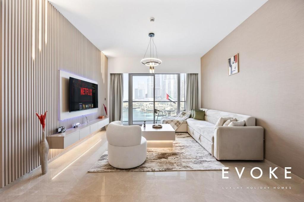 ドバイにあるGrande Residence Burj View 2 BR by Evoke Luxuryのソファと椅子とテレビのあるリビングルーム