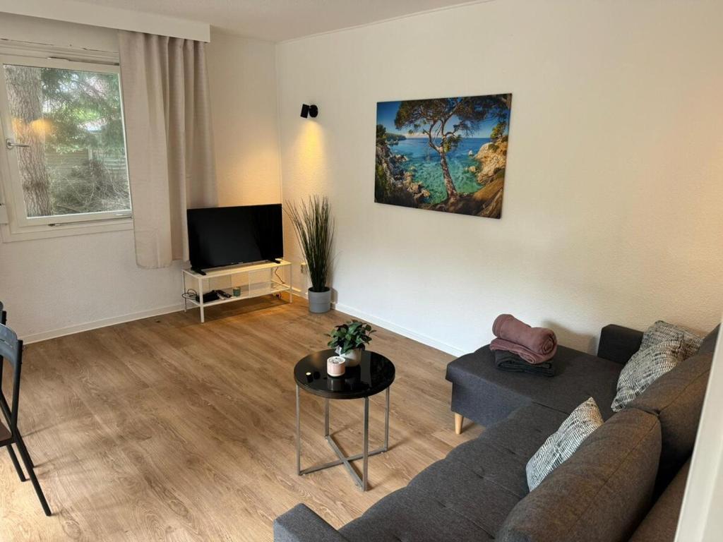 a living room with a couch and a tv at Feriendorf Seddiner See - Bungalow 4 in Seddin