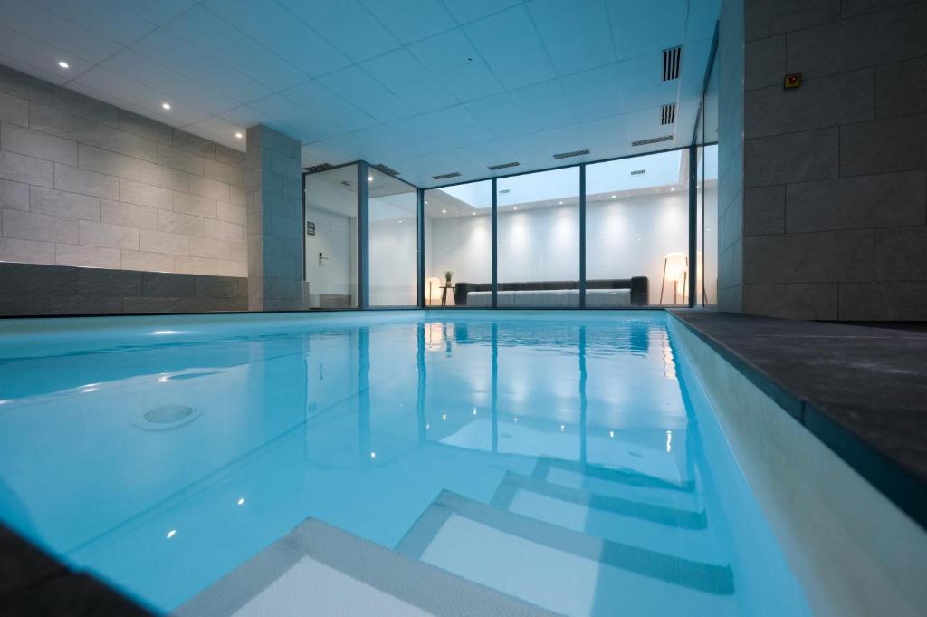 a swimming pool with blue water in a building at Nemea Appart Hotel So Cloud Lyon Gare Part-Dieu in Lyon