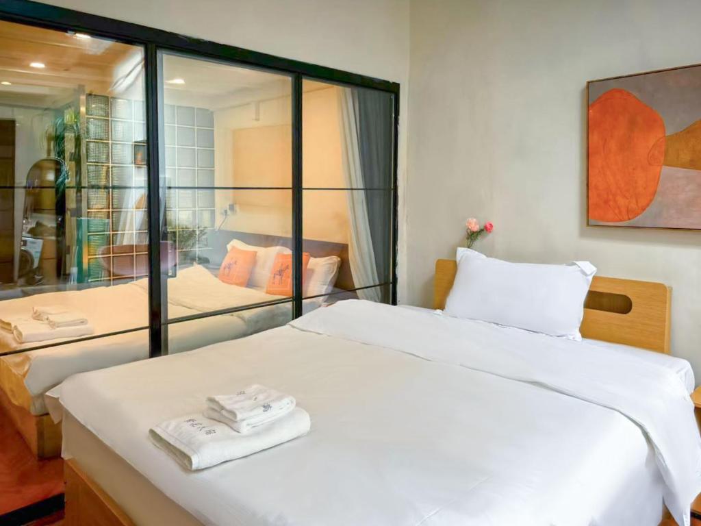 a bedroom with a large white bed and a mirror at Floral Apart mentYongkang Road in Shanghai