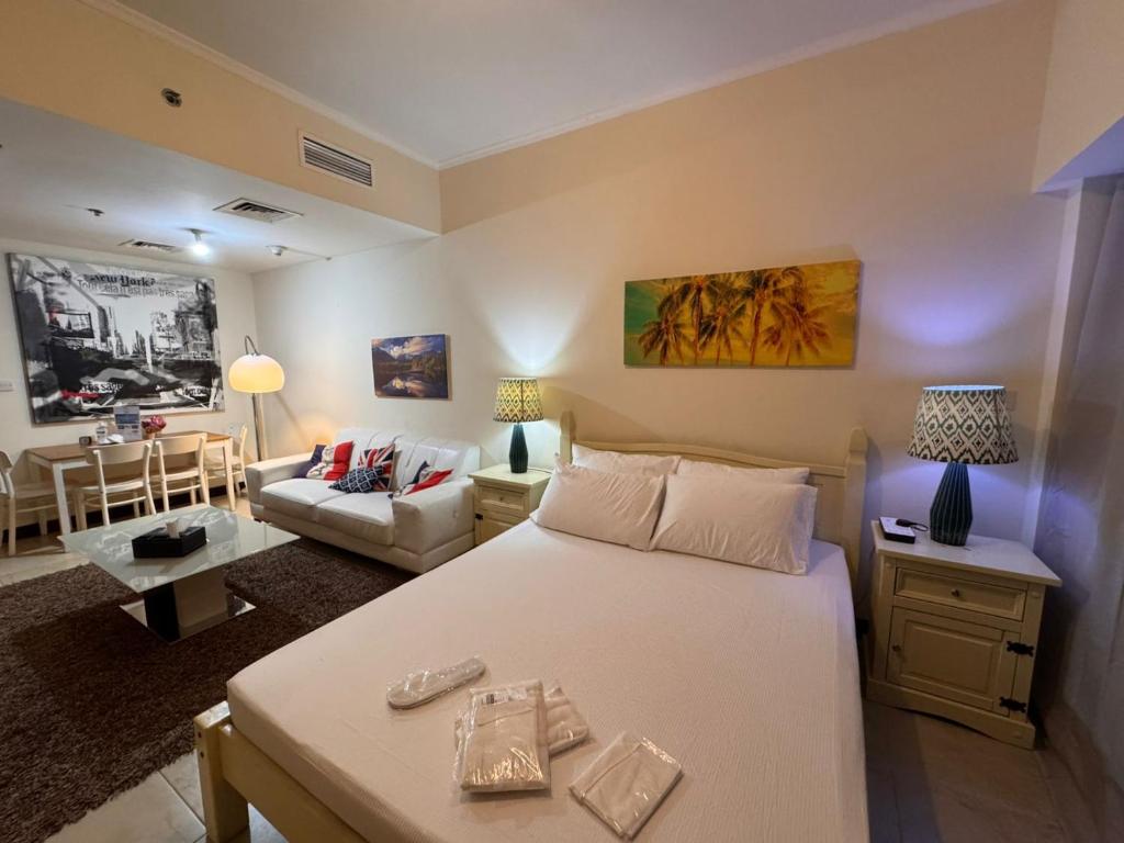 Un dormitorio con una cama y una sala de estar. en Click Stay - JLT - Entire Studio & Balcony Lakes view Apartment -AM, en Dubái