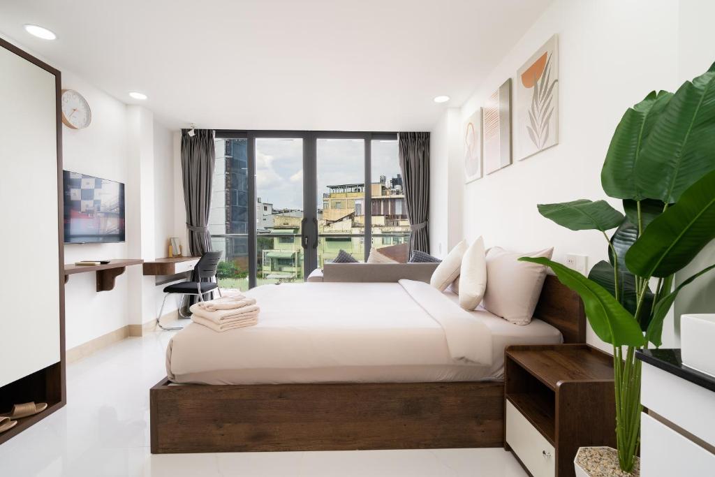 a bedroom with a bed and a large window at Ekomo Home 95 - Metro Ben Thanh in Ho Chi Minh City