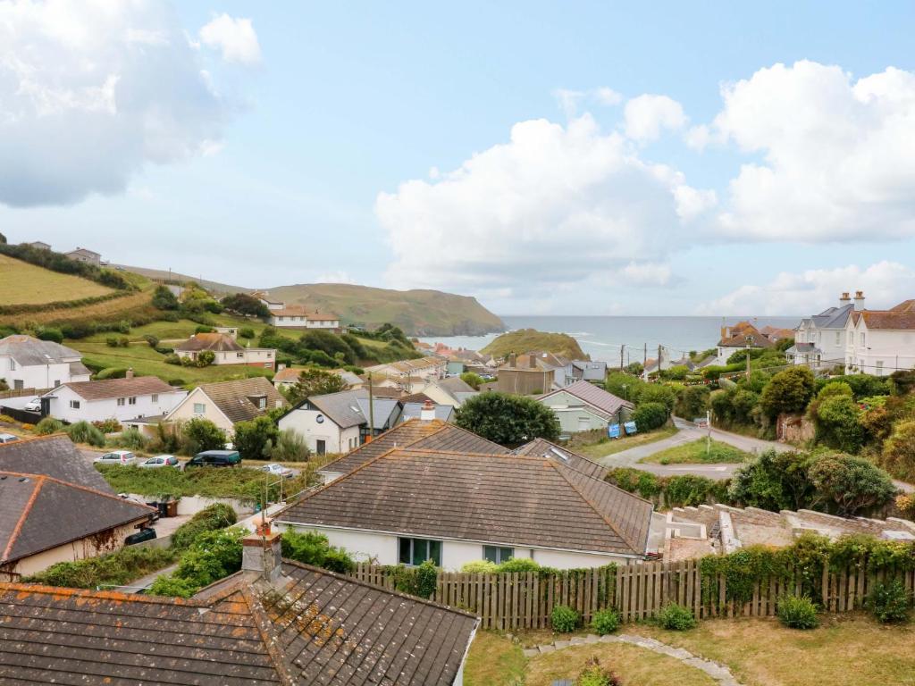 a village with houses and the ocean in the background at Surf View in Kingsbridge