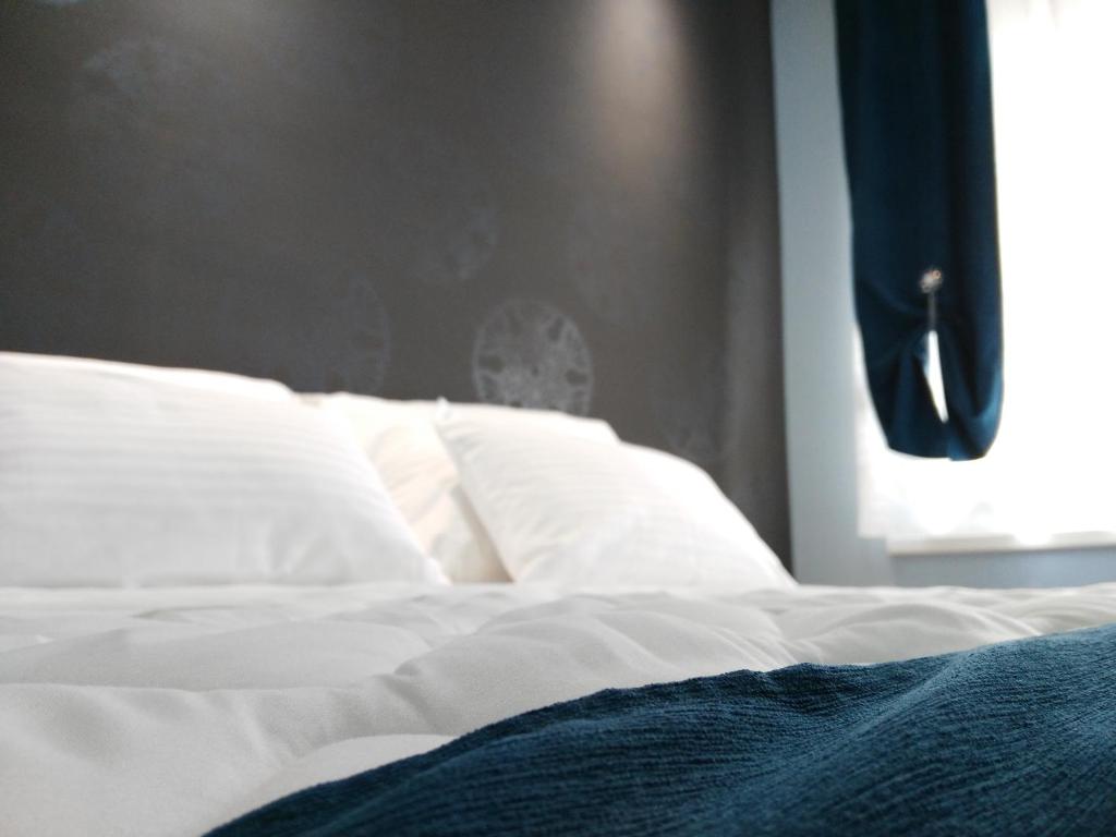 貝爾格勒的住宿－貝爾格萊德拓普公寓，一张带白色床单和窗户的未铺好的床