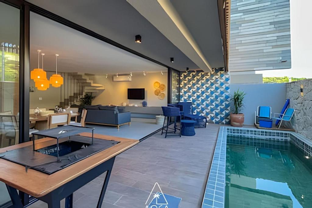 ein Haus mit einem Pool und einem Wohnzimmer in der Unterkunft Villa Kanui a 100 metros da Praia de Tatuamunha in Tatuamunha
