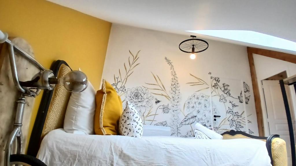 a bedroom with a bed with yellow walls at la bicyclette rouge by les étapes chartraines in Chartres