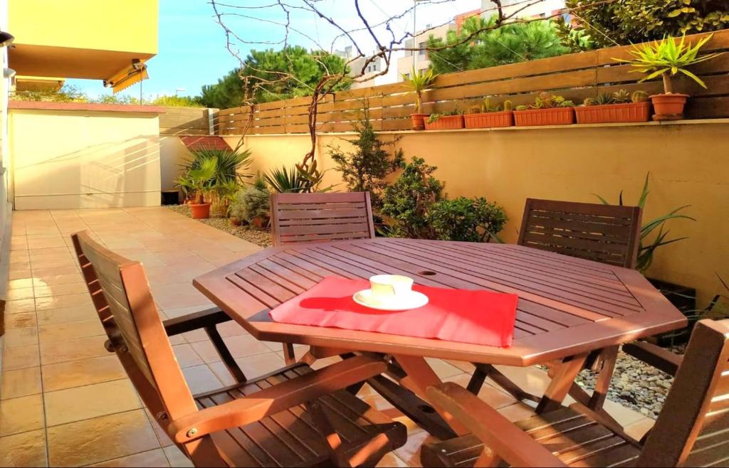 a wooden table with a red napkin on a patio at Apartment Bonito Go2lloret in Lloret de Mar