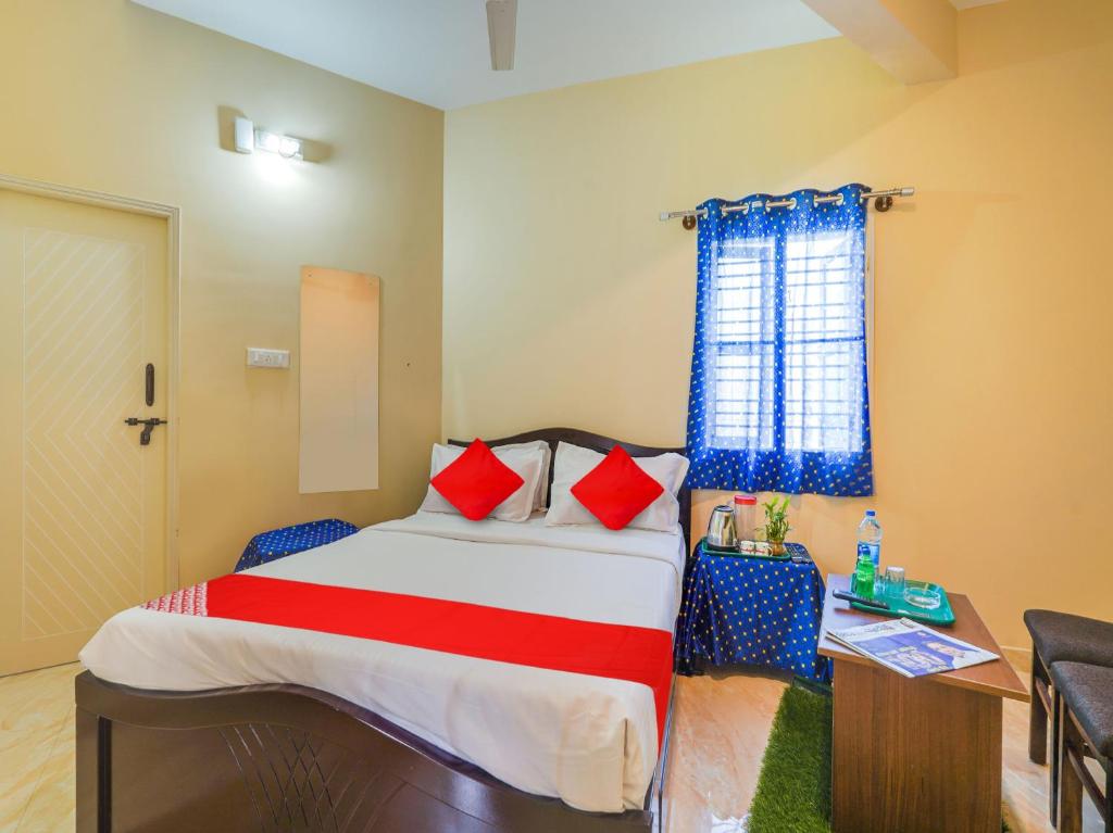 a bedroom with a large bed with red pillows at Hotel O SGR Residency in Bengaluru