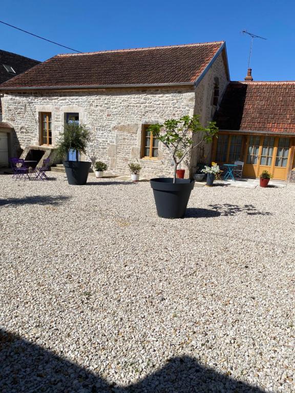 a stone house with potted plants in front of it at Gite Simon in Guillon