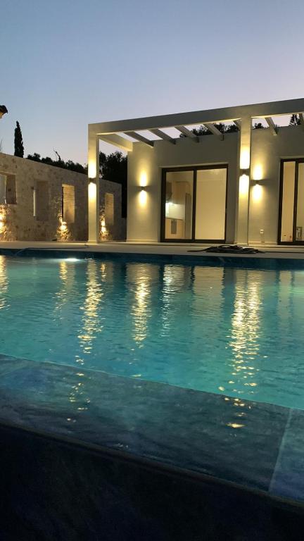 a large swimming pool in front of a house at Profil villas in Spartià