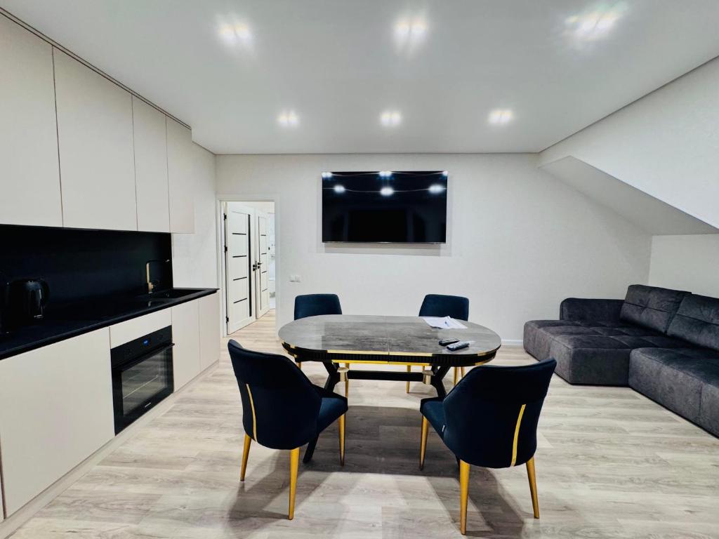een woonkamer met een tafel, stoelen en een bank bij Royal Boulevard Terrace Residence in Chişinău