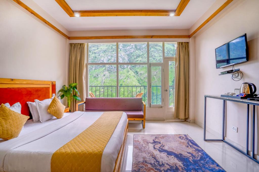 a hotel room with a bed and a large window at Deva's Retreat in Joshīmath