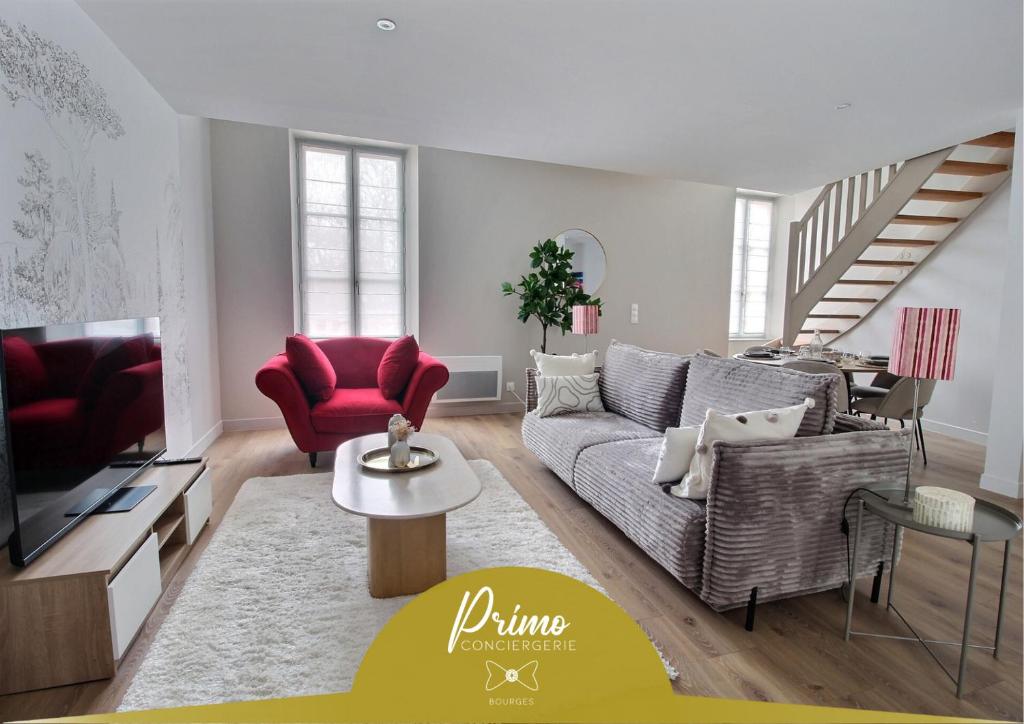 ブールジュにあるLa Suite Marcel Bascoulard - Charme et Histoireのソファとテレビのあるリビングルーム