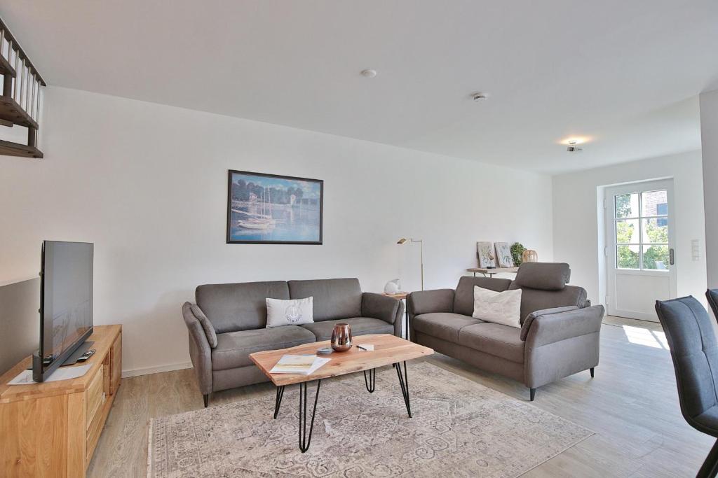 a living room with two couches and a television at Haus Oberdeck 2 in Scharbeutz