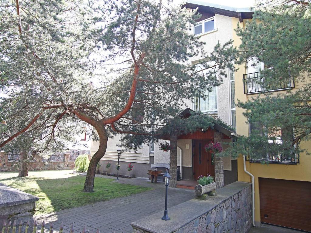 a house with a tree and a parking meter at Birutės Vila in Palanga