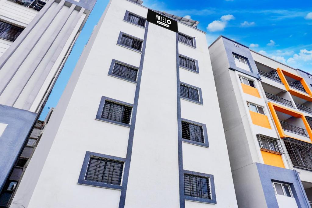 a tall white building with a street sign on it at Super Hotel O Manjari Road in Mundhwa