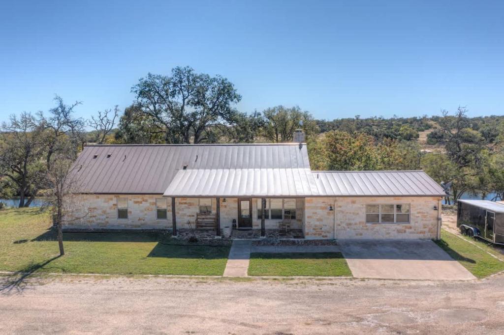 an old stone house with a metal roof at Ranch Retreat Combo with Stunning Creek View-Fire Pit in Morris Ranch