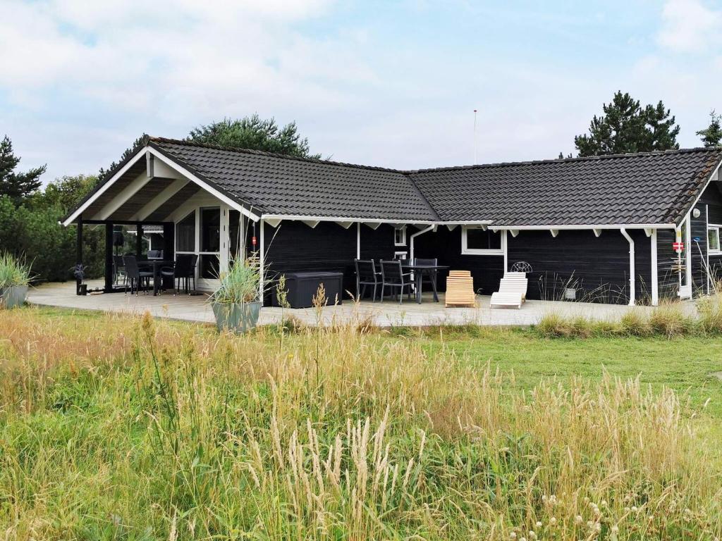 a black house with a porch and a yard at Luxury Spa Retreat by Sea - By Traum Ferienwohnungen in Trudslev