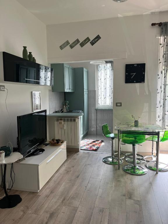 a living room with a table and green chairs at Casa Camilla in Banchette