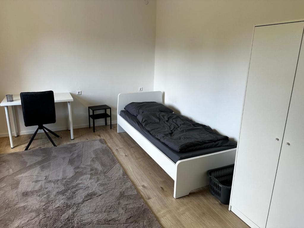 a bed in a room with a desk and a bed sidx sidx sidx at MZ Apartments in Niestetal
