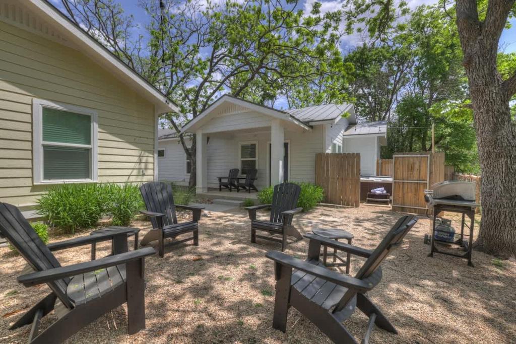 a backyard with chairs and a grill and a house at The Grove-A: Cozy Cottage 2-Blocks to Marktplatz! in Fredericksburg