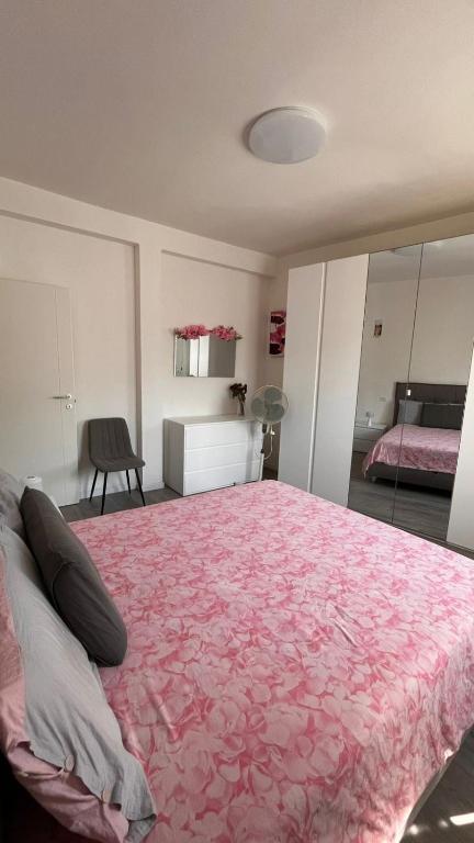 a bedroom with a large bed with a pink blanket at Nazario Sauro Cernobbio vacation home in Cernobbio
