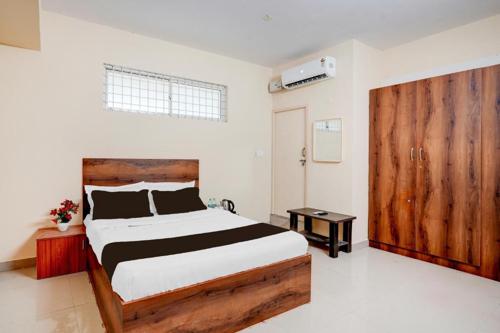 1 dormitorio con 1 cama grande y puerta de madera en Super Hotel O Abbigere Bangalore North Formerly MLV Grand, en Jālahalli