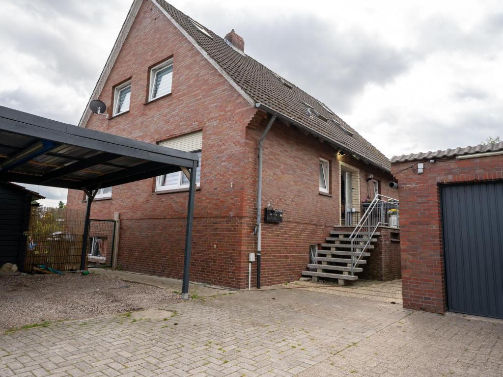 a brick house with a garage and a staircase at 216 große Ferienwohnung Schwalbennest in Wittmund