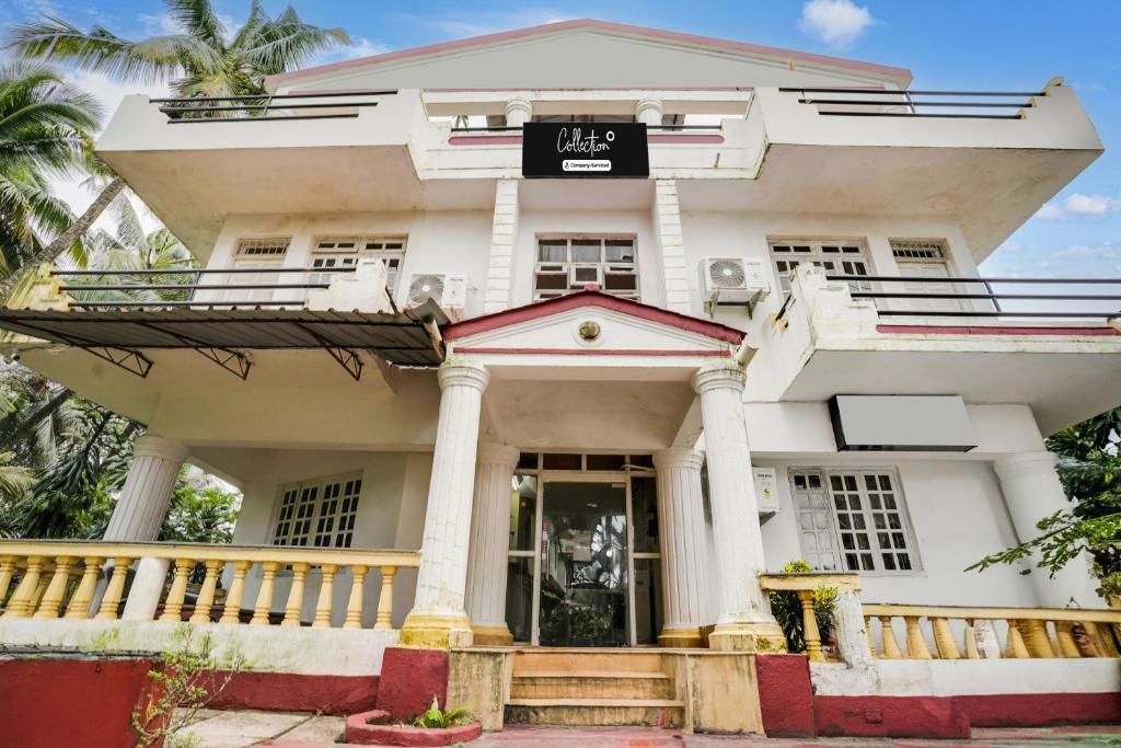 a white building with a sign on the front of it at Super Collection O Calangute in Goa