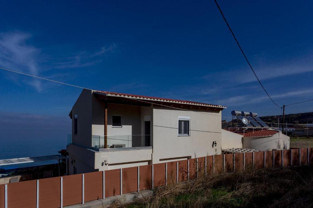a house on top of a hill with a fence at Villa Thalassa in Skaleta