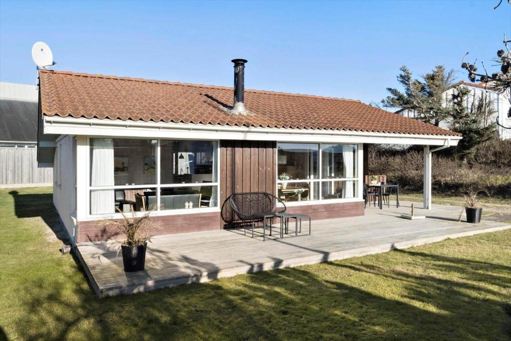 a house with a wooden deck in a yard at BL222-Blokhus-Jens-Baerentsvej-16 in Blokhus