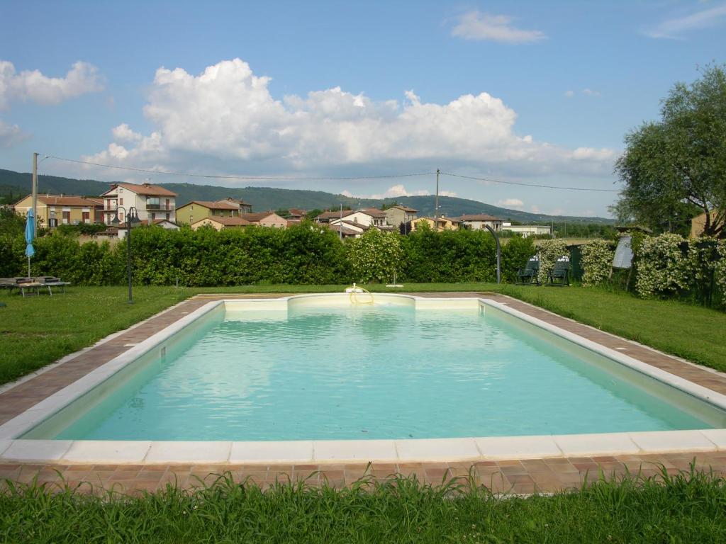 ein Schwimmbad in der Mitte eines Gartens in der Unterkunft Appartamento Vacanze Magnolia e Glicine in Tuoro sul Trasimeno