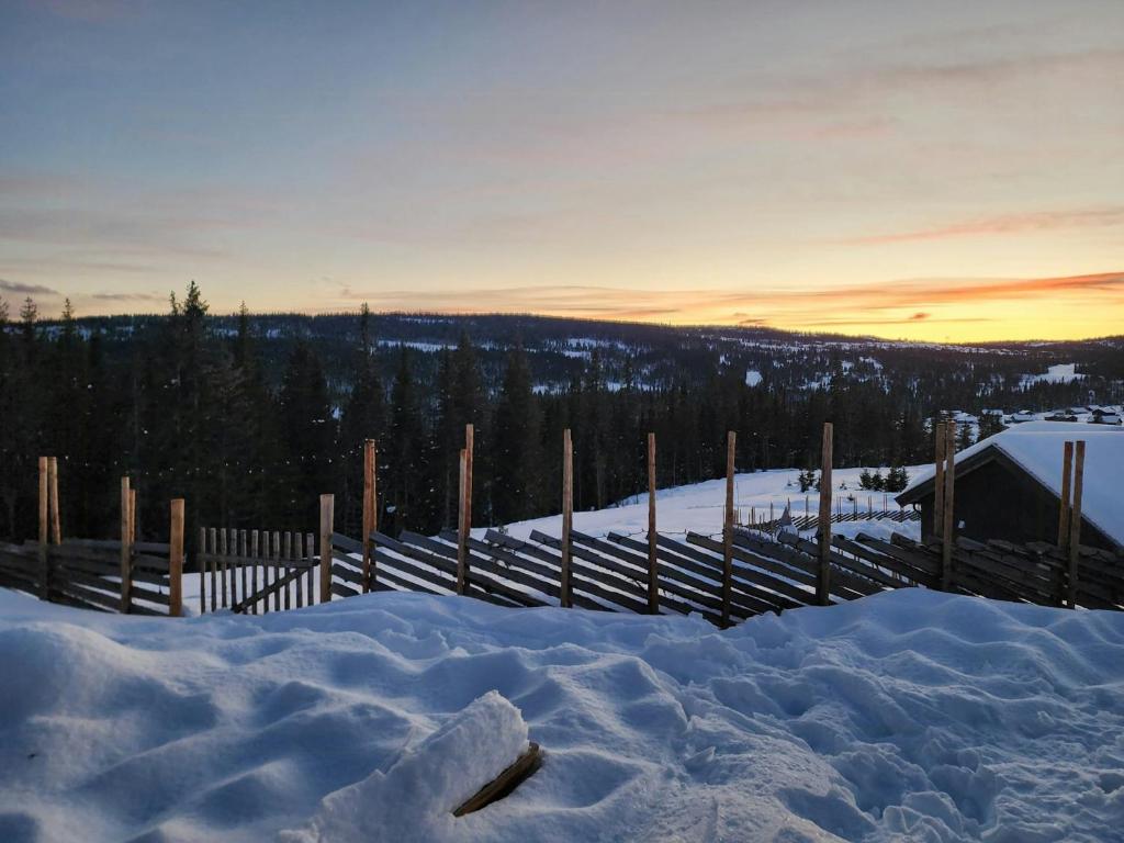 a pile of snow in front of a fence at Cabin With Forest Edge Views in Svingvoll