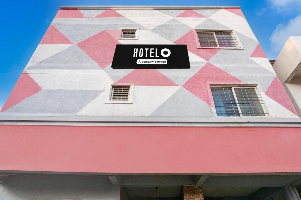a hotel sign on the side of a building at Super Hotel O Dhanori Near Pune Airport in Pune