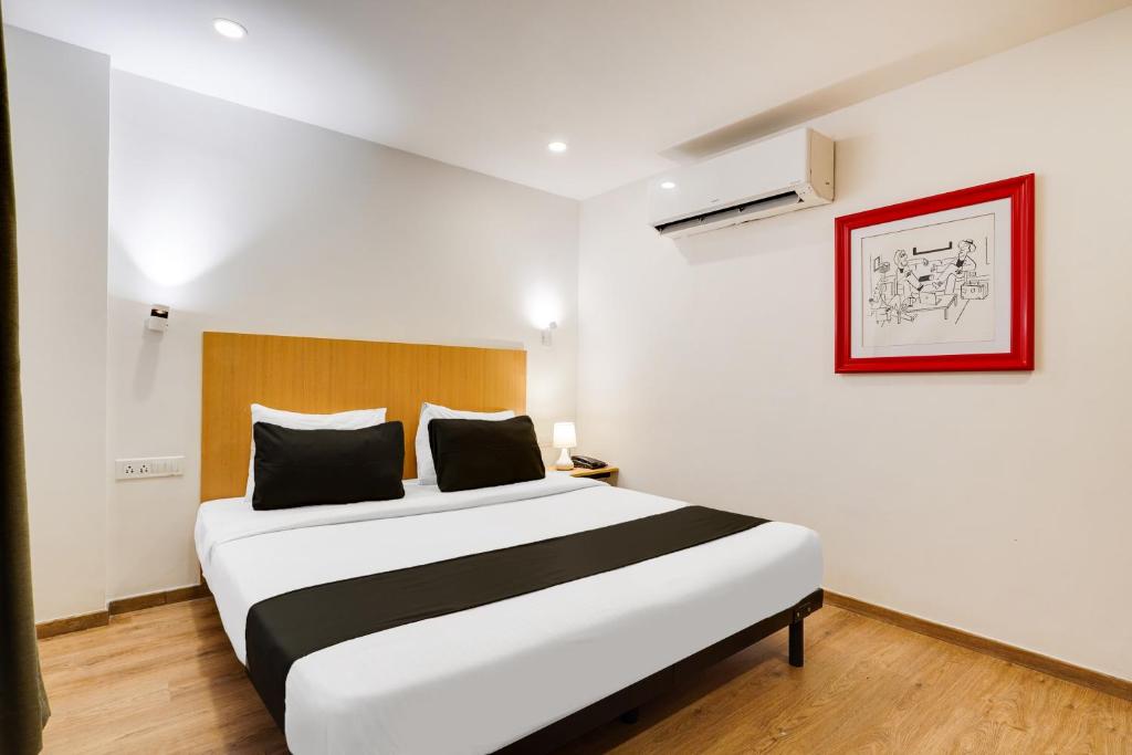 a bedroom with a large bed in a room at Super Townhouse Oak Indiranagar in Bengaluru