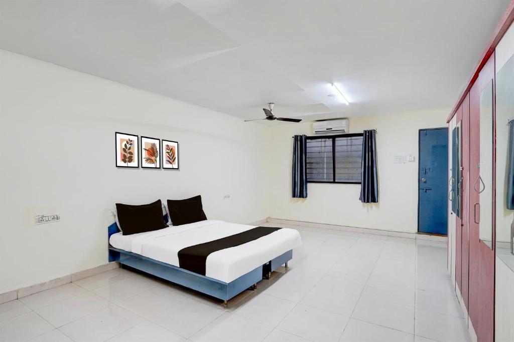 a bedroom with a bed in a white room at Hotel O Talawade IT Park Formerly AR Rooms in Dehu