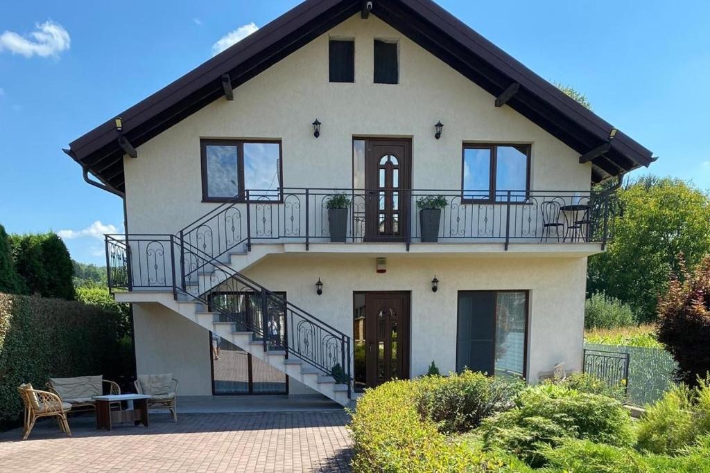 a large house with a staircase in front of it at Casa Linda in Curtea de Argeş